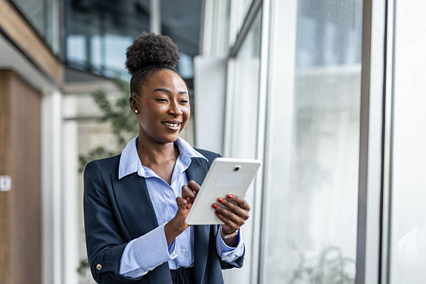 istock Black businesswoman smiling, reading data on digital tablet 2237290333