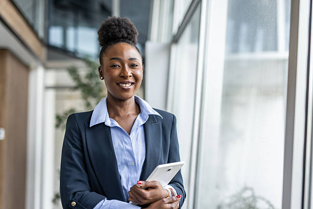 istock Confident black businesswoman standing in modern office with tablet 2237290364