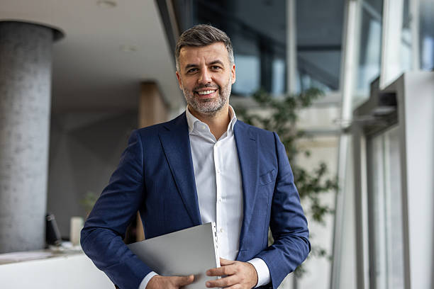 istock Businessman holding laptop smiling in modern office environment 2237290507