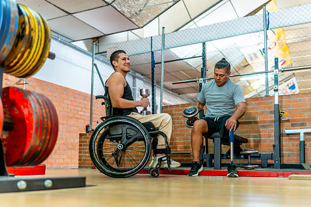 istock Disabled men training in gym, lifting dumbbells with focus 2237290584