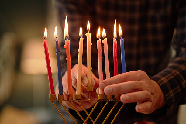 istock Man Lighting Candles on Menorah Celebrating Hanukkah 2237293234