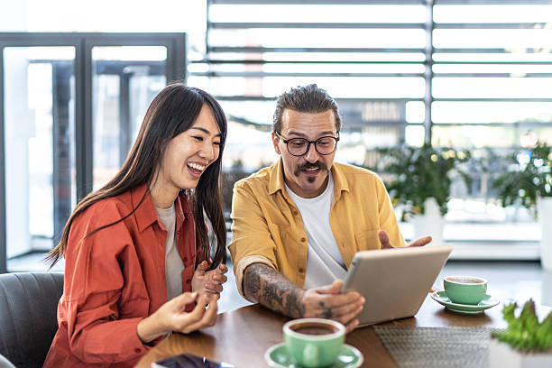 istock Diverse friends laughing at tablet screen in cafe 2237293478