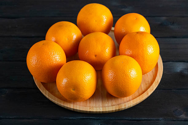 istock Fresh oranges on wooden plate 2237293812