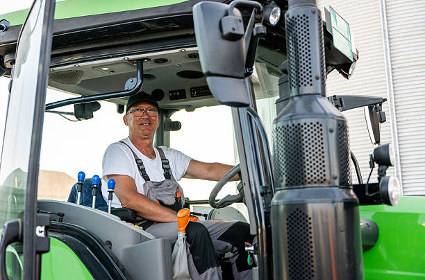 istock Senior farmer driving tractor with loaded trailers to the silos 2237295002