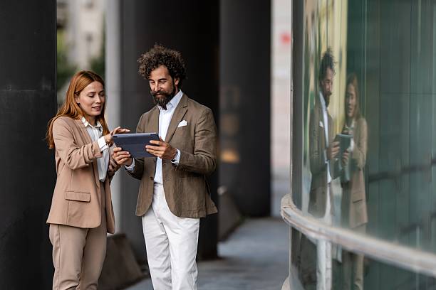 istock Businesspeople using digital tablet outside office building 2237295993