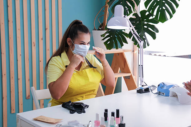 istock nail master talking to the client in a beauty salon putting on mask 2237296937