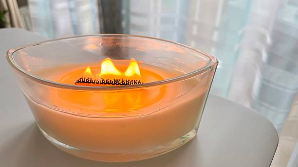 istock Large scented candle in glass jar burning in cozy home interior 2237297892