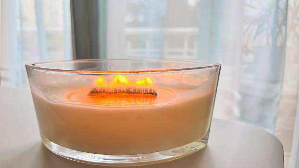 istock Large scented candle in glass jar burning in cozy home interior 2237297902