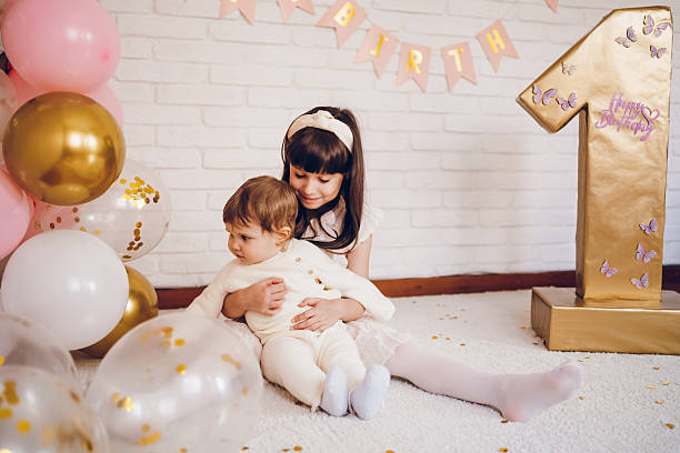 Cute girl with her sister baby celebrating a birthday.