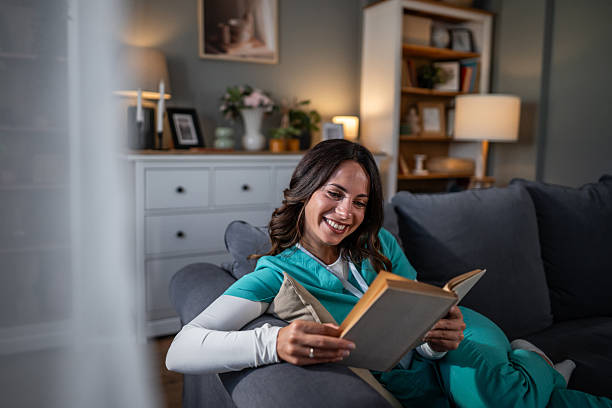 istock Healthcare worker relaxing at home reading book after work 2237301584