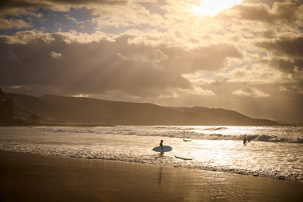 Surfers during beautiful sunset, Las Palmas, Gran Canaria, Spain