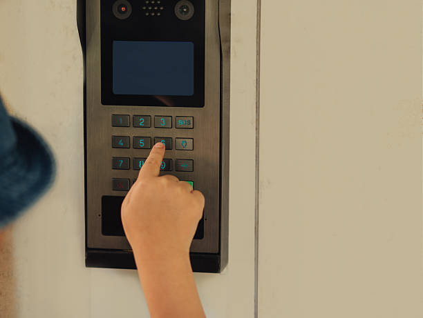 istock Girl using a door entry phone intercom entering the code to enter a building. 2237303846