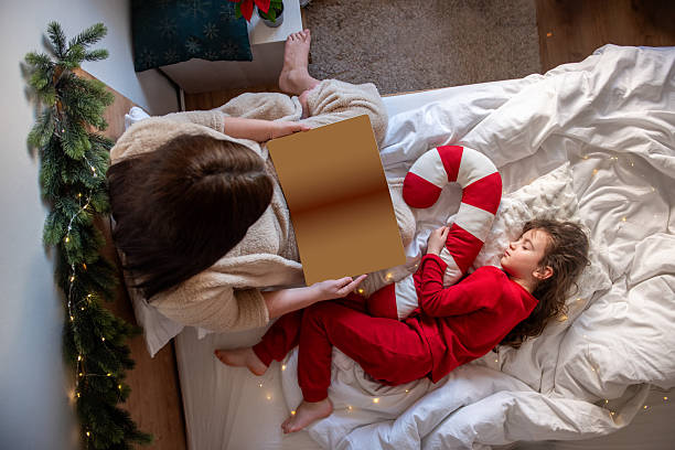 Mother reading Christmas story to sleeping child
