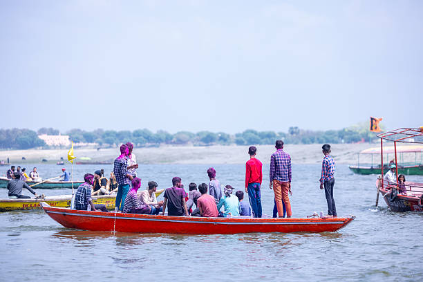 Varanasi, Uttar Pradesh, India - March 2024: Masan Holi, Group of unidentified devotee with painted face with organic colors in wooden boat during the celebration of masan holi at manikarnika ghat.