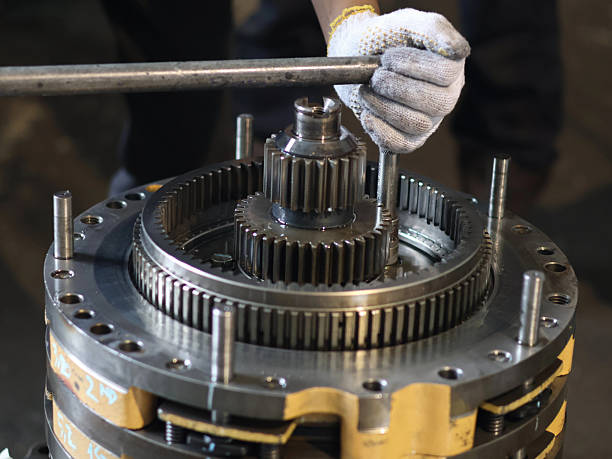istock Close-up of a person's hands working on a transmission planetary gear, highlighting the process of tighten bolt with long handle, industrial setting. 2237308022