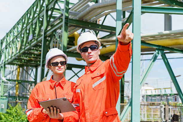 istock Industrial engineers in safety gear checking refinery pipelines. 2237308347