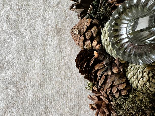 Textured background with natural Christmas decor elements (pine cones, moss, old metal). Negative space for minimalist holiday sale or greeting design.