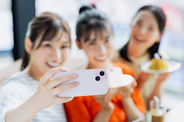 istock Young woman taking a photo while eating cake at a cafe 2237310647