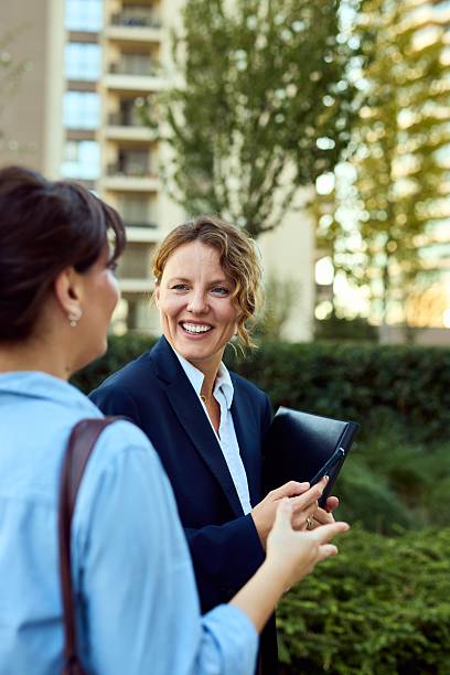 istock Professional Women Conversing Outdoors in Business Attire With Folder in Urban Office Setting 2237310754