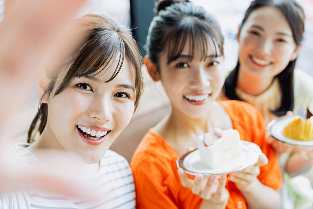 istock Young woman taking a photo while eating cake at a cafe 2237310898