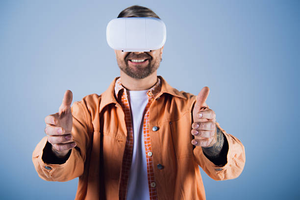 A young man smiles joyfully while immersed in a virtual world using a VR headset.