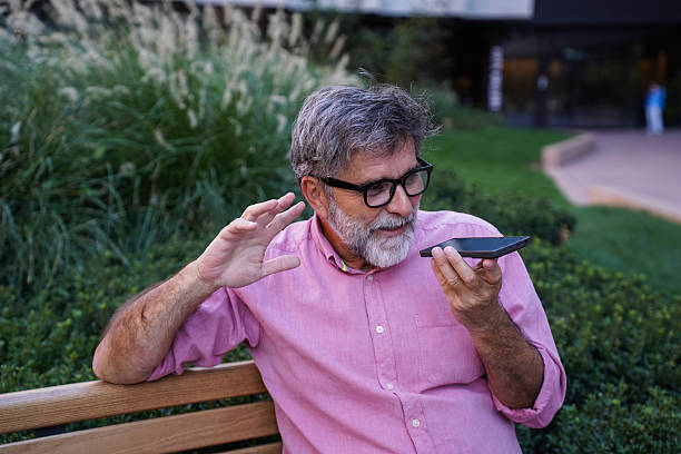 istock Senior man using smartphone and drinking coffee on a park bench 2237312830