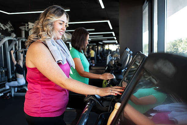 istock Two friends are running side by side on treadmills, keeping each other motivated. 2237318955
