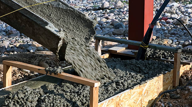 istock Pouring wet concrete from a mixer truck into a formwork on a construction site. Foundational work. Workers control a concrete mix flows through the gutter. Building industry. High quality photo 2237322737