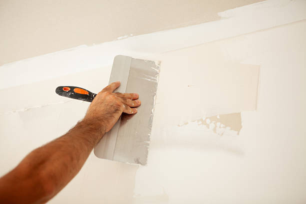 istock Close-up of a worker painting a wall with a spatula 2237325057