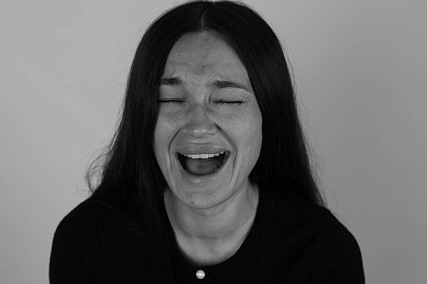 istock Woman in deep laughter, eyes shut, mouth wide open 2237325192