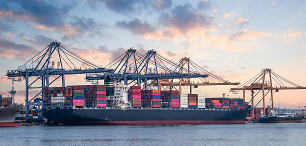 istock Logistics and container loading by large barges by sea in a harbor full of containers waiting to be transported 2237327283
