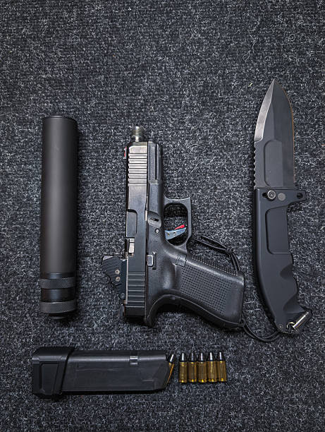 istock A modern tactical weapon set featuring a semi-automatic pistol with a suppressor, knife, magazine, and 9mm ammunition. 2237327606