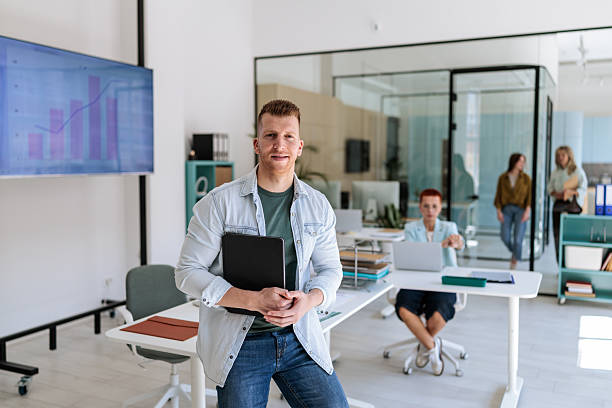 istock Smiling Businessman Holding Folder in Office 2237328466