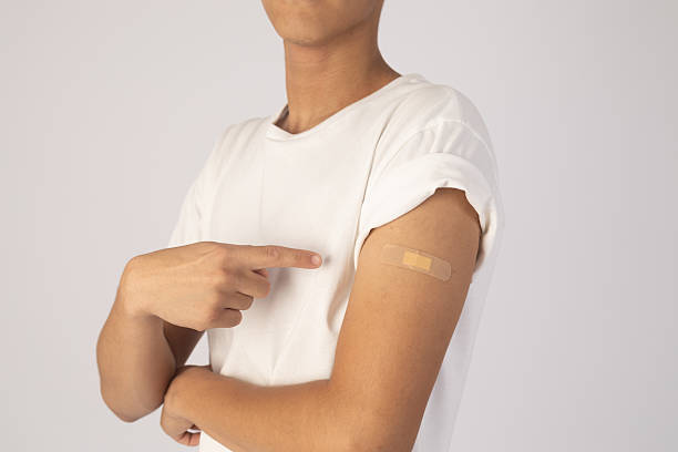 istock Young boy is pointing to a bandage on their upper arm 2237329640