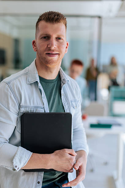 istock Smiling Businessman Holding Folder in Office 2237331808
