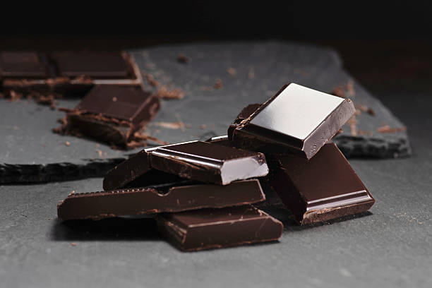 istock Broken dark chocolate and cocoa powder on a dark table 2237332092