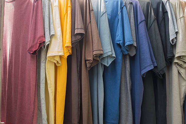 istock Colorful t-shirts hanging on a rack in a shop. 2237334751