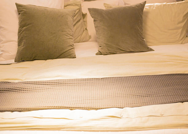 Close up of bedding sheets and pillows in hotel bedroom interior