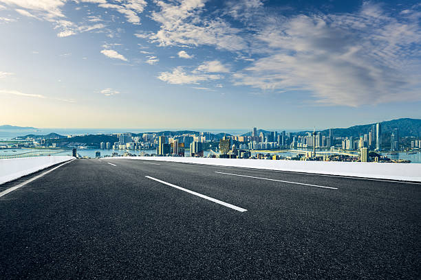 istock Empty asphalt road with a modern city skyline and sea view. 2237335595