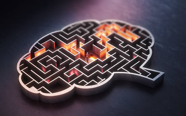 istock Businessman Seeking a Solution on a Orange-Lighted Path in a Dark Concrete Maze Shaped Like a Human Brain 2237335774