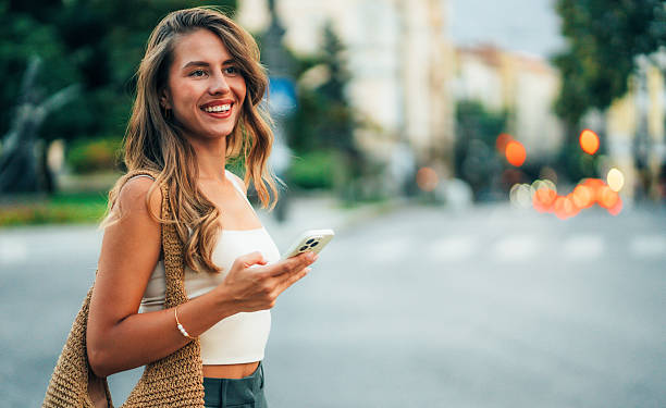 istock Beautiful woman using mobile in the street 2237341632