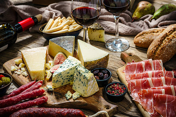 istock Cheese board and red wine. Mediterranean appetizer on rustic table. Spanish tapas or antipasto. Tasty food for snack or party. Cured ham, chorizo or cold cuts 2237342124