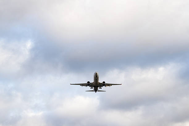 istock A passenger airplane with its landing gear down is approaching for landing in a cloudy sky. 2237343640
