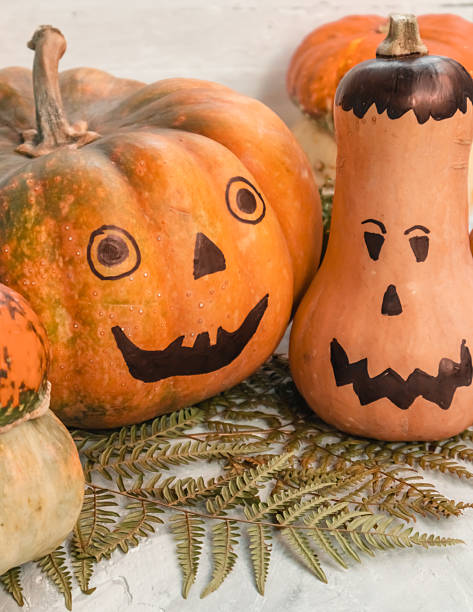 istock Festive decorated pumpkins close up on a light background. Halloween concept. 2237345940