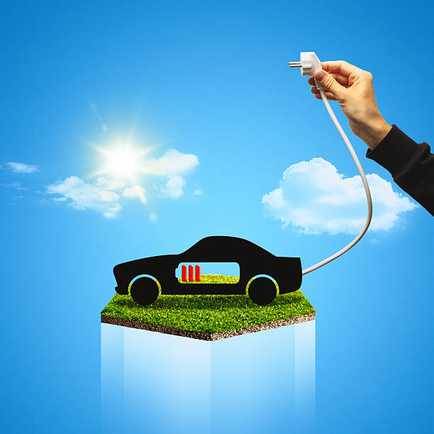 A sleek electric car charges outdoors at sunset, with a glowing golden sky creating a serene scene. The modern design emphasizes sustainability and innovation.