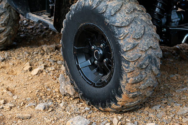 istock A black tire with mud on it is on a rocky surface 2237348238