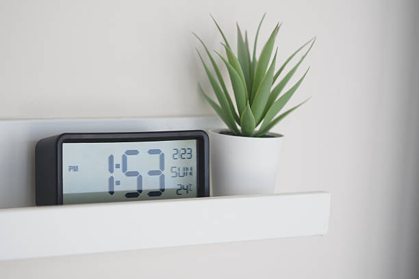 istock Digital clock and potted plant on a modern wall shelf at home 2237351954