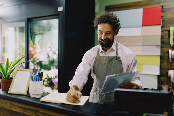 istock Florist Taking and Writing Down Orders in Flower Shop 2237353690