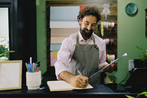 istock Florist Taking and Writing Down Orders in Flower Shop 2237354623