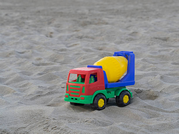 colorful truck cement (concrete) mixer plastic toy on the sand dunes